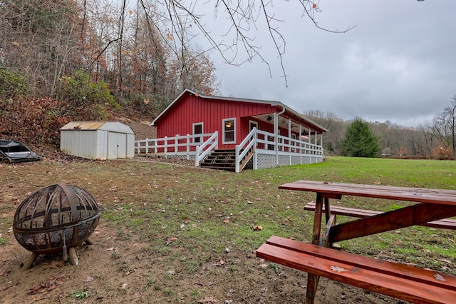 view of yard featuring a fire pit and a storage unit