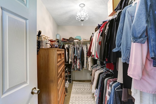 walk in closet with a notable chandelier