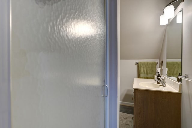 full bathroom with vaulted ceiling, an enclosed shower, and vanity