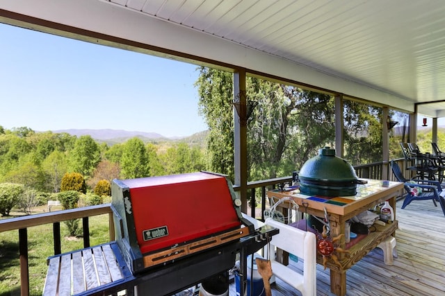 wooden deck with a grill and a mountain view