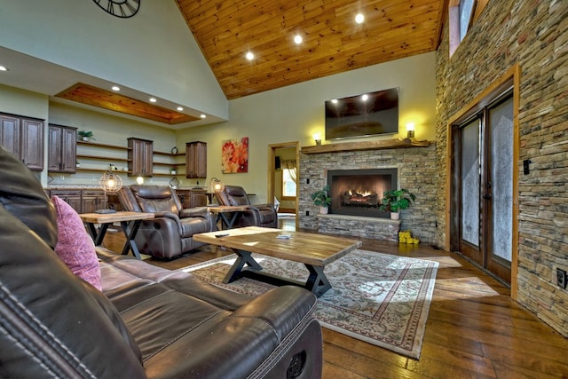 living area with recessed lighting, wood ceiling, a stone fireplace, high vaulted ceiling, and hardwood / wood-style flooring