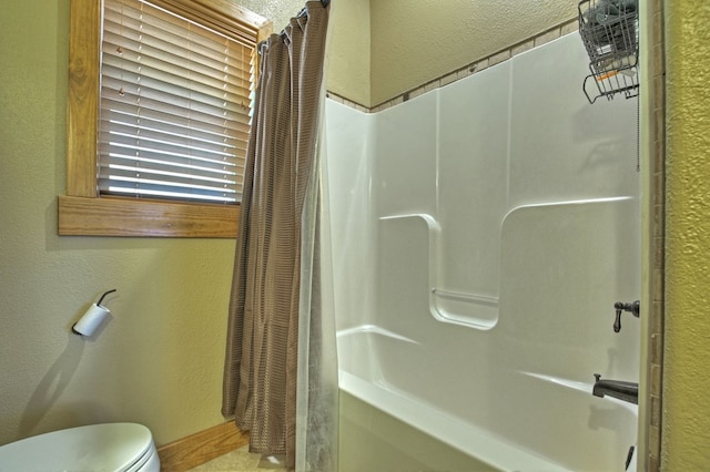 full bathroom featuring a textured wall, toilet, and shower / bathtub combination with curtain