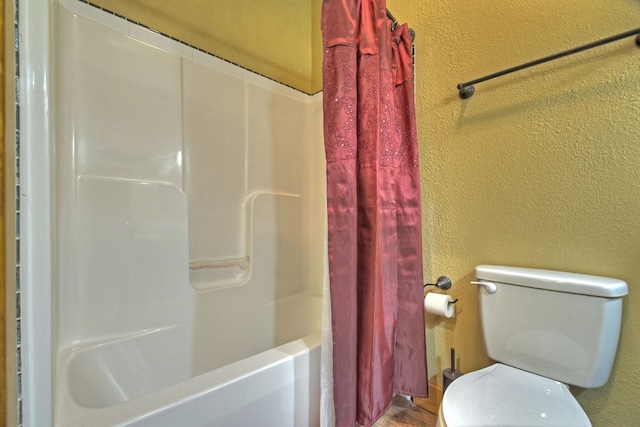 bathroom featuring toilet, shower / tub combo with curtain, and a textured wall