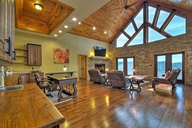 living area featuring wooden ceiling, dark wood-style floors, french doors, a fireplace, and high vaulted ceiling