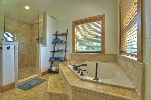 bathroom featuring a jetted tub, a walk in shower, a wealth of natural light, and tile patterned floors