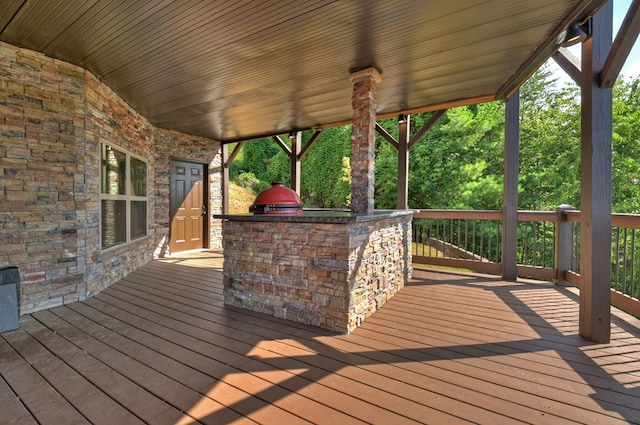 wooden terrace featuring area for grilling and a grill