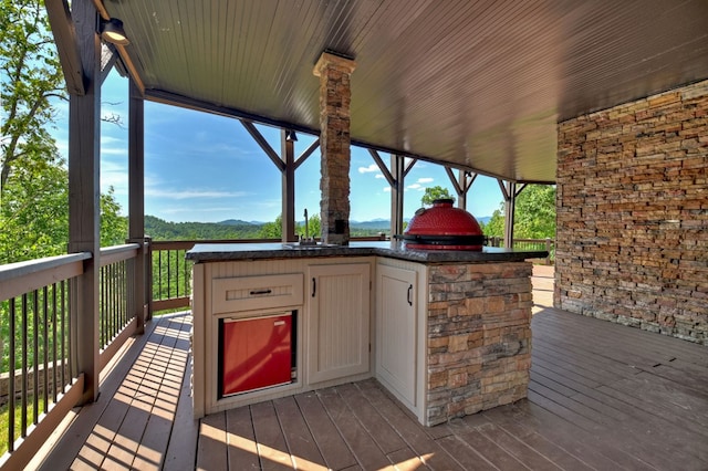 wooden terrace featuring an outdoor kitchen and a mountain view