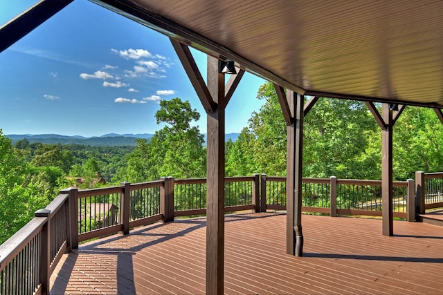 wooden terrace featuring a mountain view and a wooded view