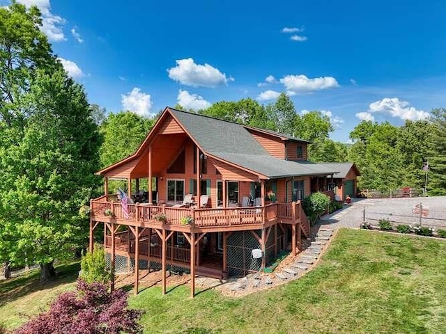 back of property featuring a lawn, a wooden deck, and stairway