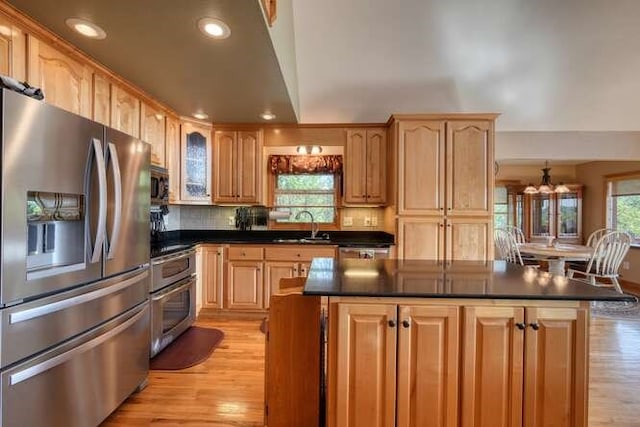 kitchen featuring recessed lighting, appliances with stainless steel finishes, dark countertops, and light wood-type flooring