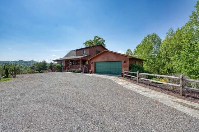 246 Serenity Pointe Dr, Murphy, NC 28906 - rustic home featuring an attached garage, fence, driveway, and covered porch