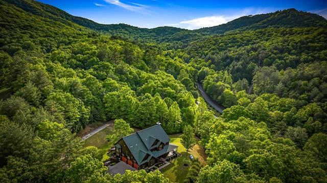 view from above of property featuring a heavily wooded area and a mountain backdrop