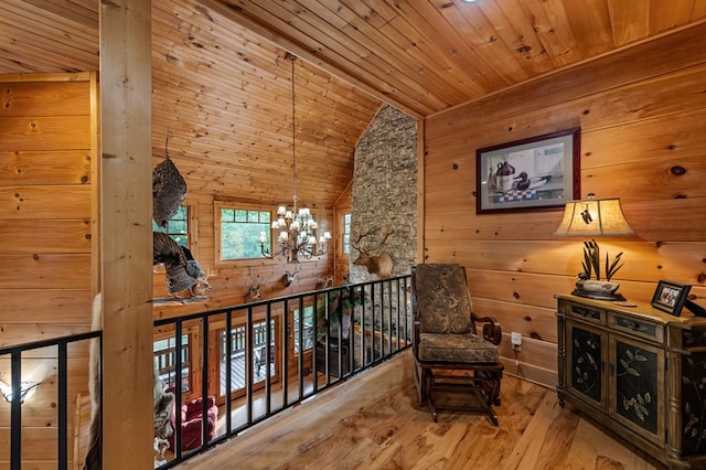 sitting room featuring wood walls, wood finished floors, wooden ceiling, a chandelier, and high vaulted ceiling