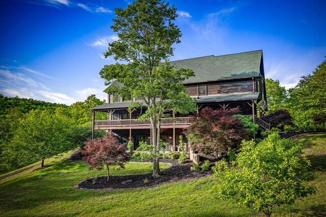 rear view of property featuring a yard and a deck