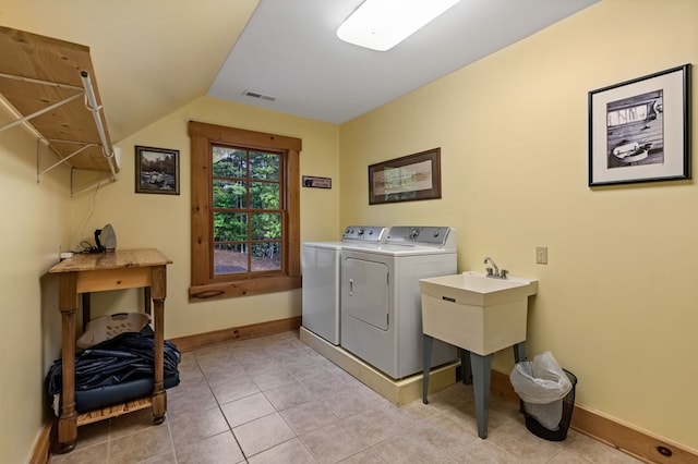 laundry area featuring washer and dryer, baseboards, and light tile patterned floors