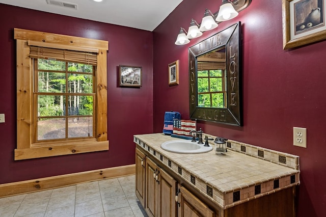 bathroom with baseboards, vanity, and tile patterned flooring