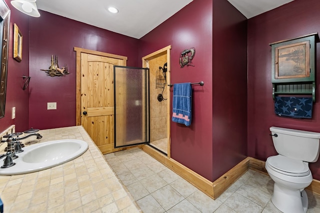 bathroom featuring a sink, a shower stall, toilet, and tile patterned floors