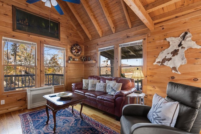 living room featuring beamed ceiling, wooden walls, and wooden ceiling