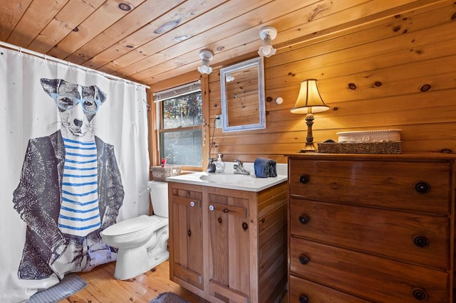 bathroom with wooden walls, hardwood / wood-style flooring, vanity, toilet, and wooden ceiling