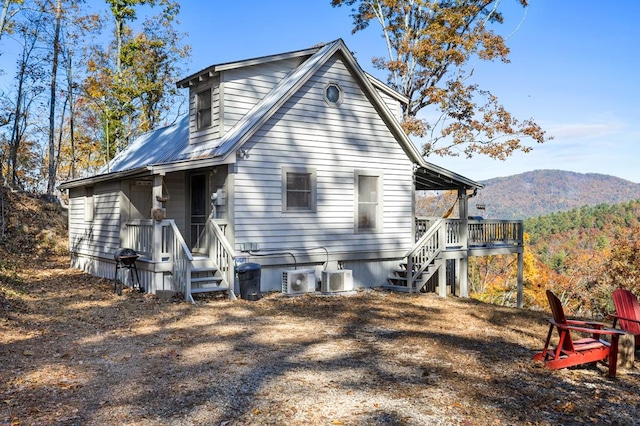 back of house with a mountain view and central AC unit