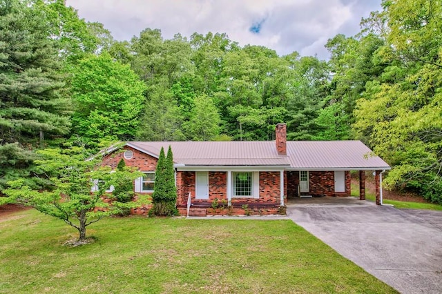 ranch-style house with a chimney, brick siding, metal roof, concrete driveway, and an attached carport