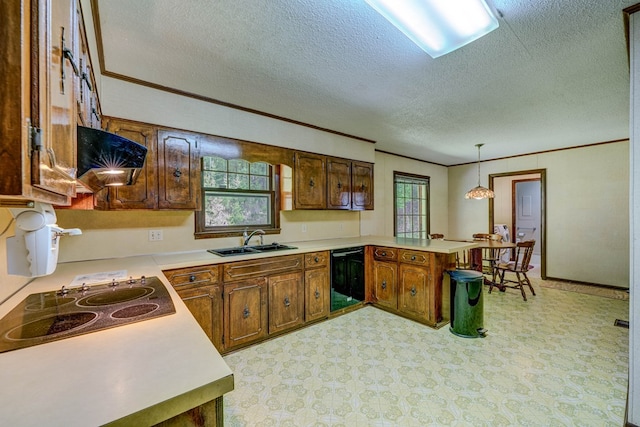 kitchen featuring a peninsula, crown molding, light countertops, and a sink