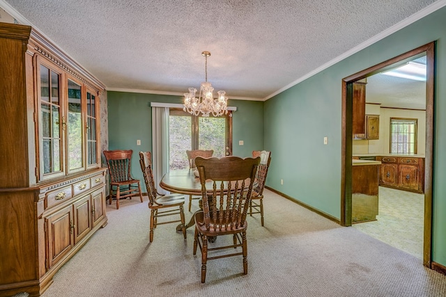 dining space featuring a textured ceiling, baseboards, ornamental molding, an inviting chandelier, and light colored carpet