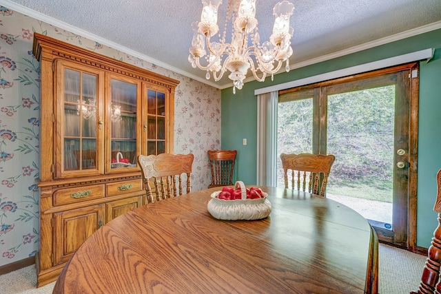 carpeted dining area with wallpapered walls, a textured ceiling, baseboards, ornamental molding, and a chandelier
