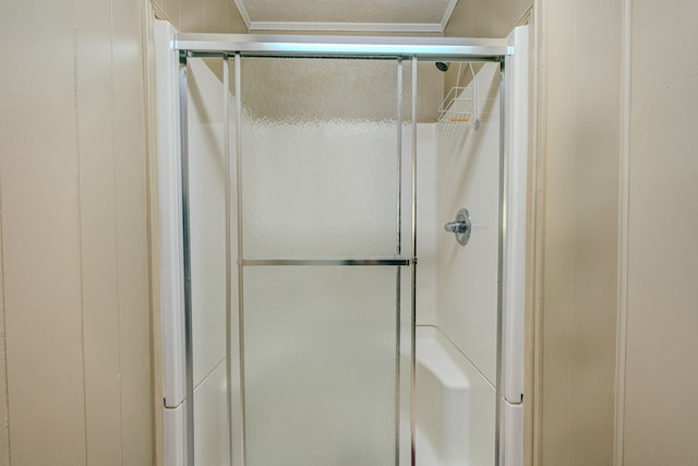 full bath featuring a stall shower and crown molding