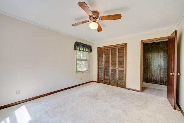 unfurnished bedroom with carpet, baseboards, ceiling fan, and crown molding