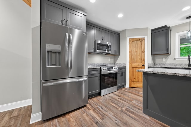 89 Pamela Ct, Ellijay, GA 30540 - kitchen featuring appliances with stainless steel finishes, light wood-style flooring, light stone counters, gray cabinets, and recessed lighting