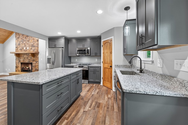 89 Pamela Ct, Ellijay, GA 30540 - kitchen with stainless steel appliances, gray cabinets, wood finished floors, a kitchen island, and light stone counters