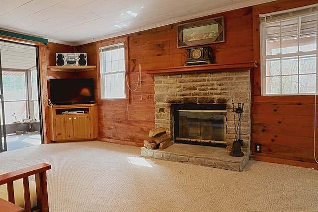 living room featuring wood ceiling, a stone fireplace, carpet flooring, and wooden walls