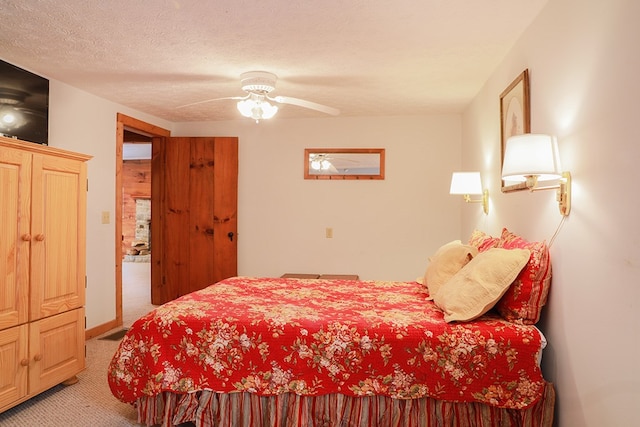 bedroom featuring light carpet, ceiling fan, and a textured ceiling