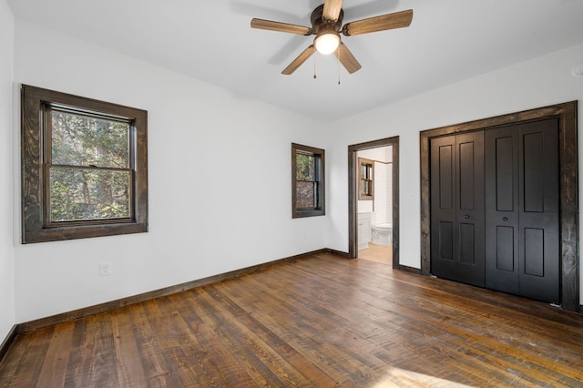 unfurnished bedroom featuring ceiling fan, dark hardwood / wood-style floors, a closet, and ensuite bath