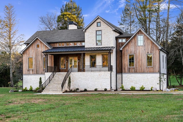 modern farmhouse featuring covered porch and a front yard