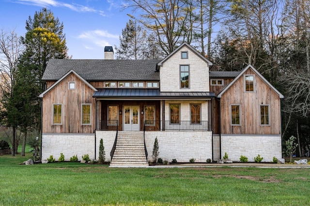 modern inspired farmhouse with a front yard, covered porch, and french doors