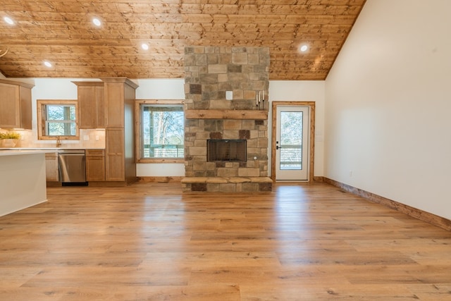 unfurnished living room with light wood-style flooring, a fireplace, baseboards, and high vaulted ceiling