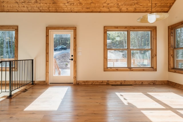 interior space featuring a wealth of natural light, baseboards, and wood finished floors