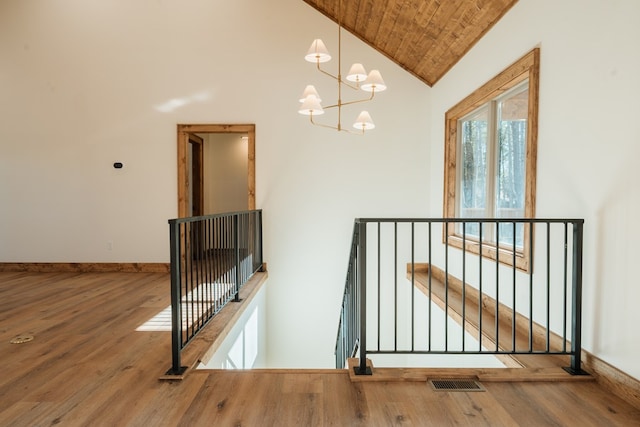 interior space featuring visible vents, high vaulted ceiling, an inviting chandelier, and wood finished floors