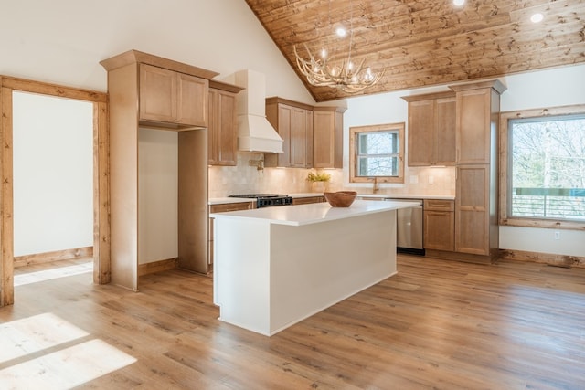 kitchen featuring light wood-style flooring, an inviting chandelier, light countertops, custom exhaust hood, and dishwasher