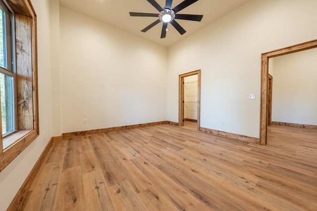 empty room featuring a wealth of natural light, light wood-type flooring, and ceiling fan