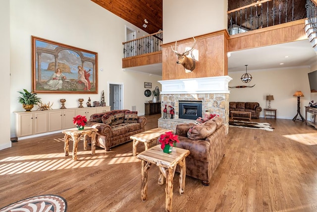 33 Tj Mote Rd, Dahlonega, GA 30533 - living room with a high ceiling, a stone fireplace, light wood-type flooring, baseboards, and crown molding