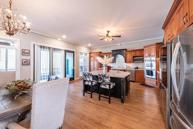 33 Tj Mote Rd, Dahlonega, GA 30533 - kitchen featuring stainless steel appliances, light countertops, brown cabinetry, light wood finished floors, and a chandelier