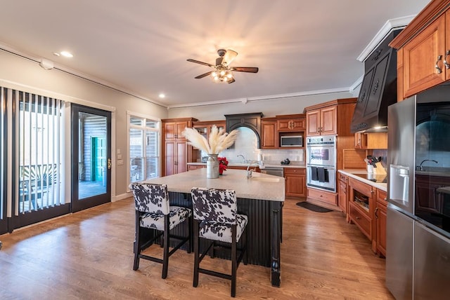 33 Tj Mote Rd, Dahlonega, GA 30533 - kitchen with stainless steel appliances, a ceiling fan, brown cabinets, a breakfast bar area, and ornamental molding