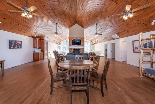 33 Tj Mote Rd, Dahlonega, GA 30533 - dining space featuring lofted ceiling, a glass covered fireplace, wood finished floors, a ceiling fan, and baseboards