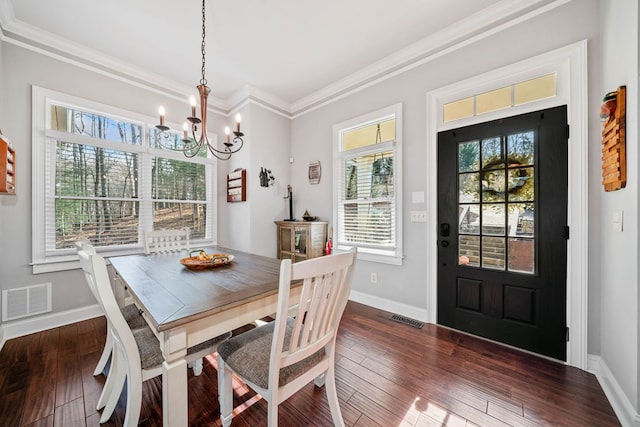 dining area featuring a chandelier, dark hardwood / wood-style floors, and crown molding