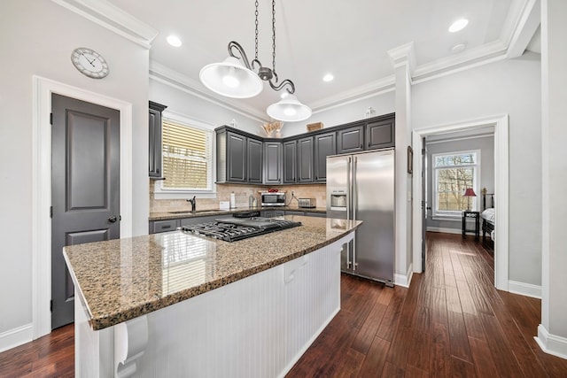 kitchen with a kitchen island, light stone countertops, stainless steel appliances, and dark wood-type flooring