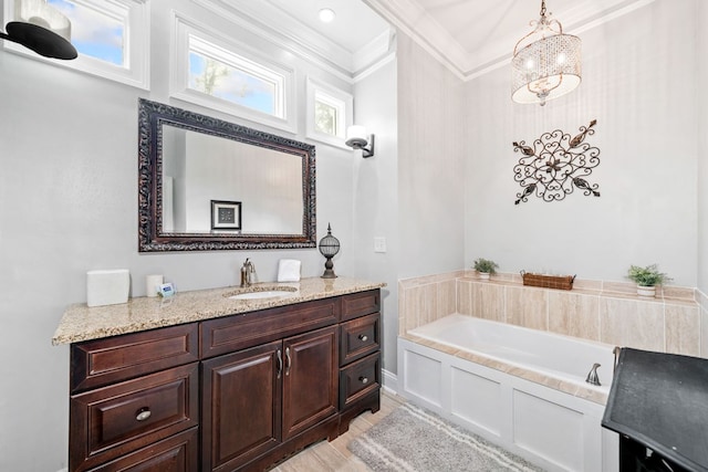 bathroom with a bathing tub, vanity, and crown molding