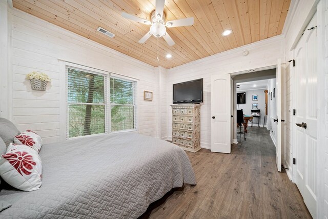 bedroom with ceiling fan, wooden walls, wood-type flooring, and wooden ceiling